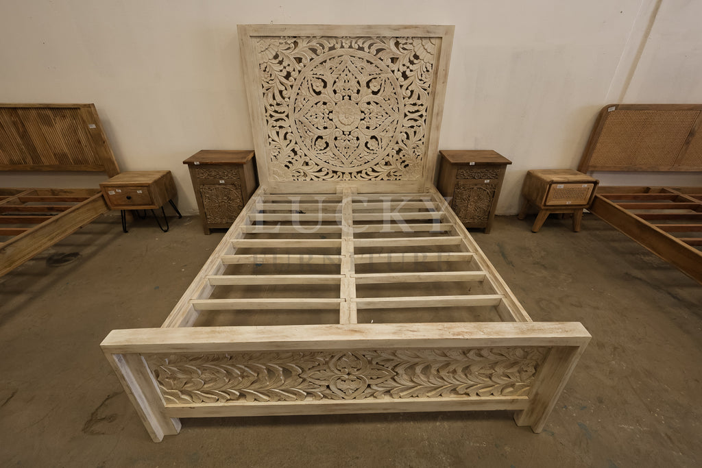 Carved whitewashed wooden bed.