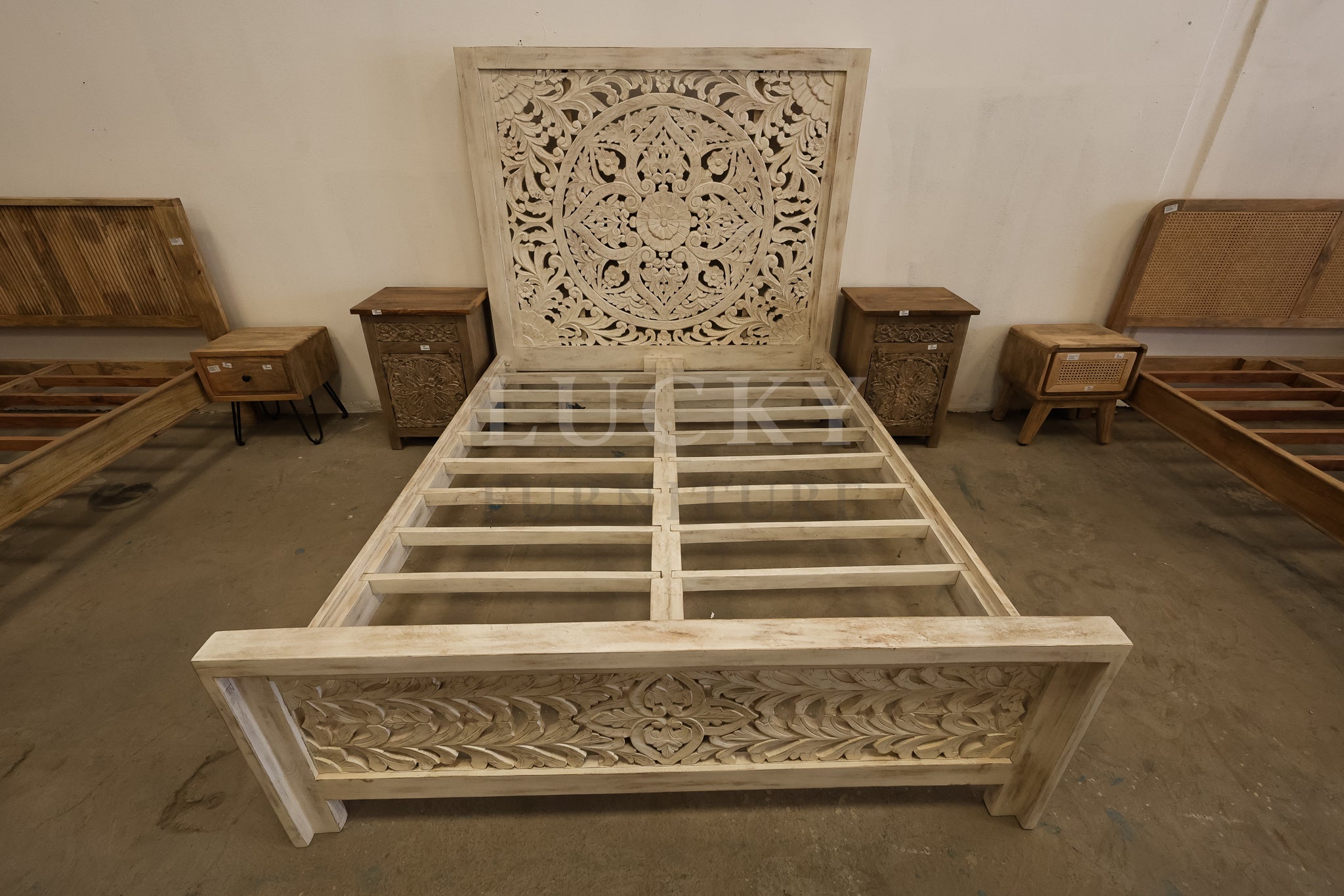 Carved whitewashed wooden bed.