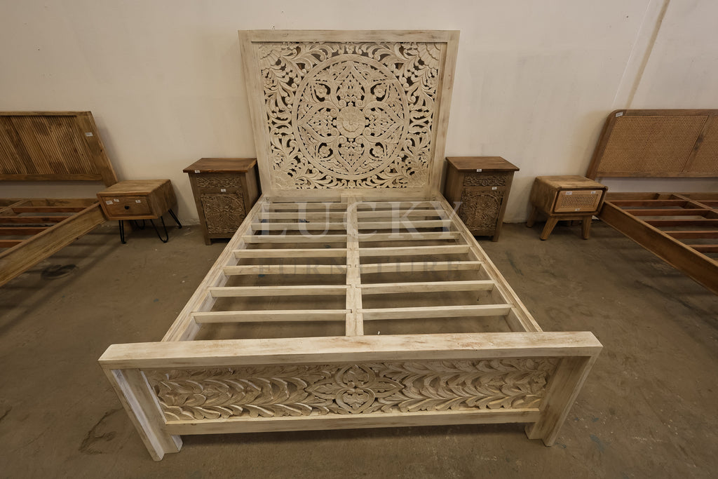 Carved whitewashed wooden bed.