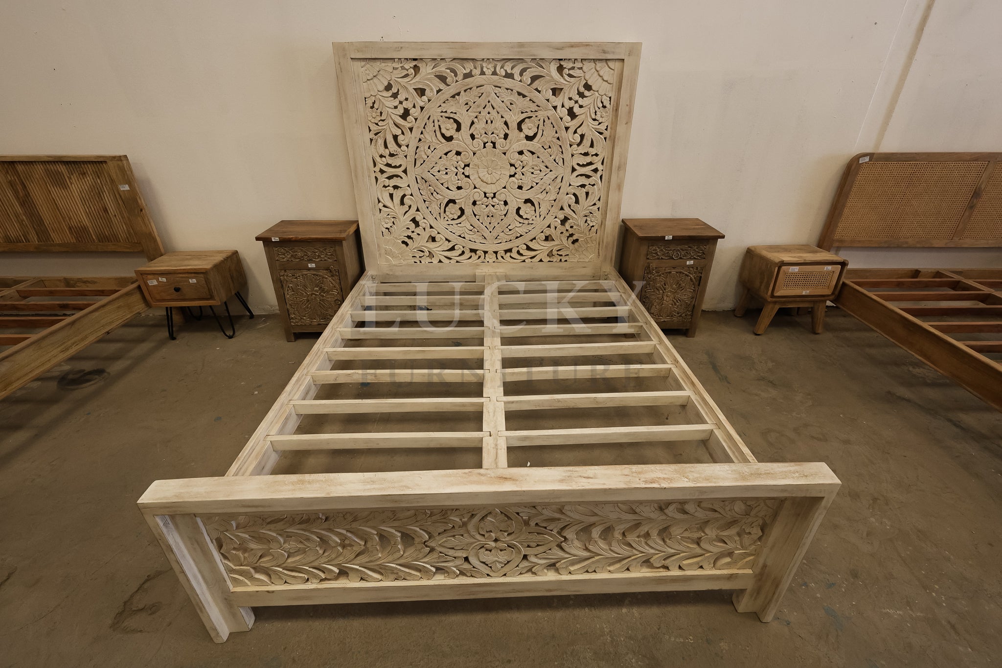 Carved whitewashed wooden bed.