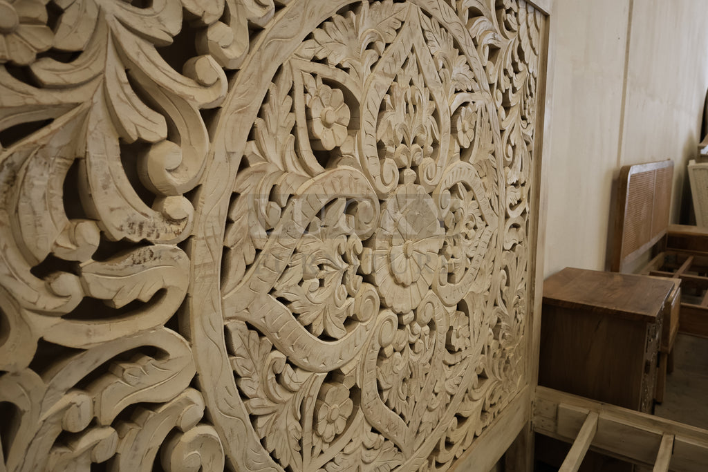 Carved whitewashed wooden bed.