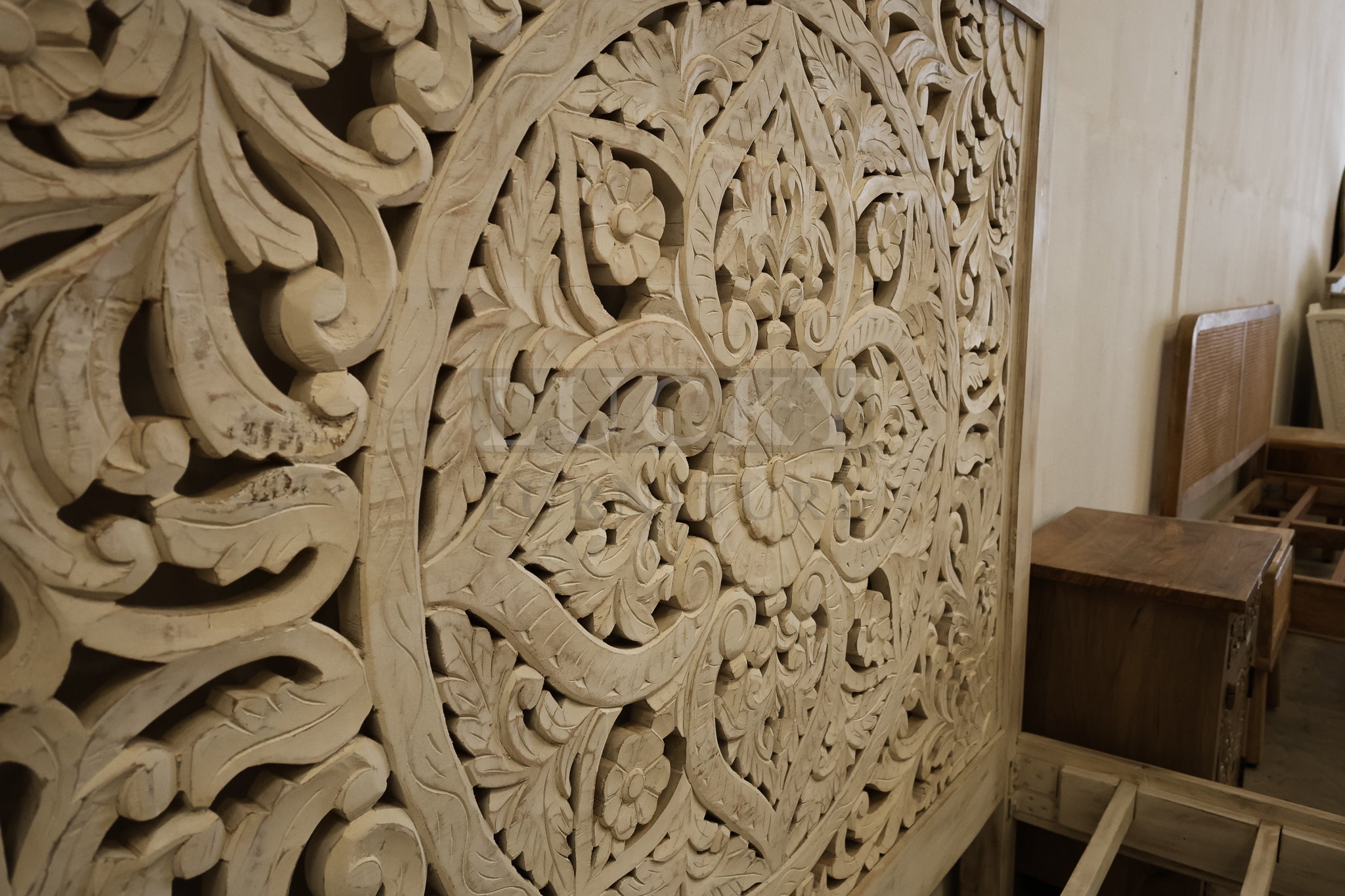 Carved whitewashed wooden bed.