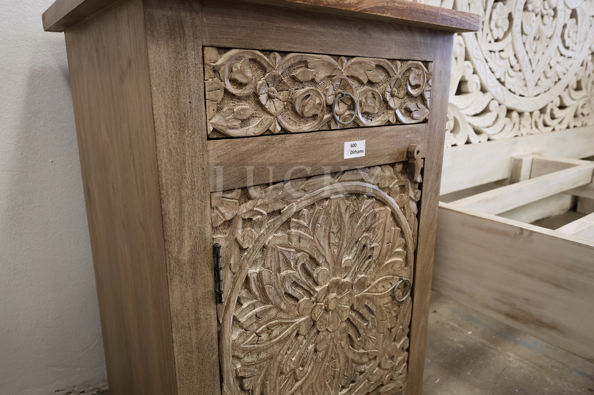 Carved whitewashed wooden bed.