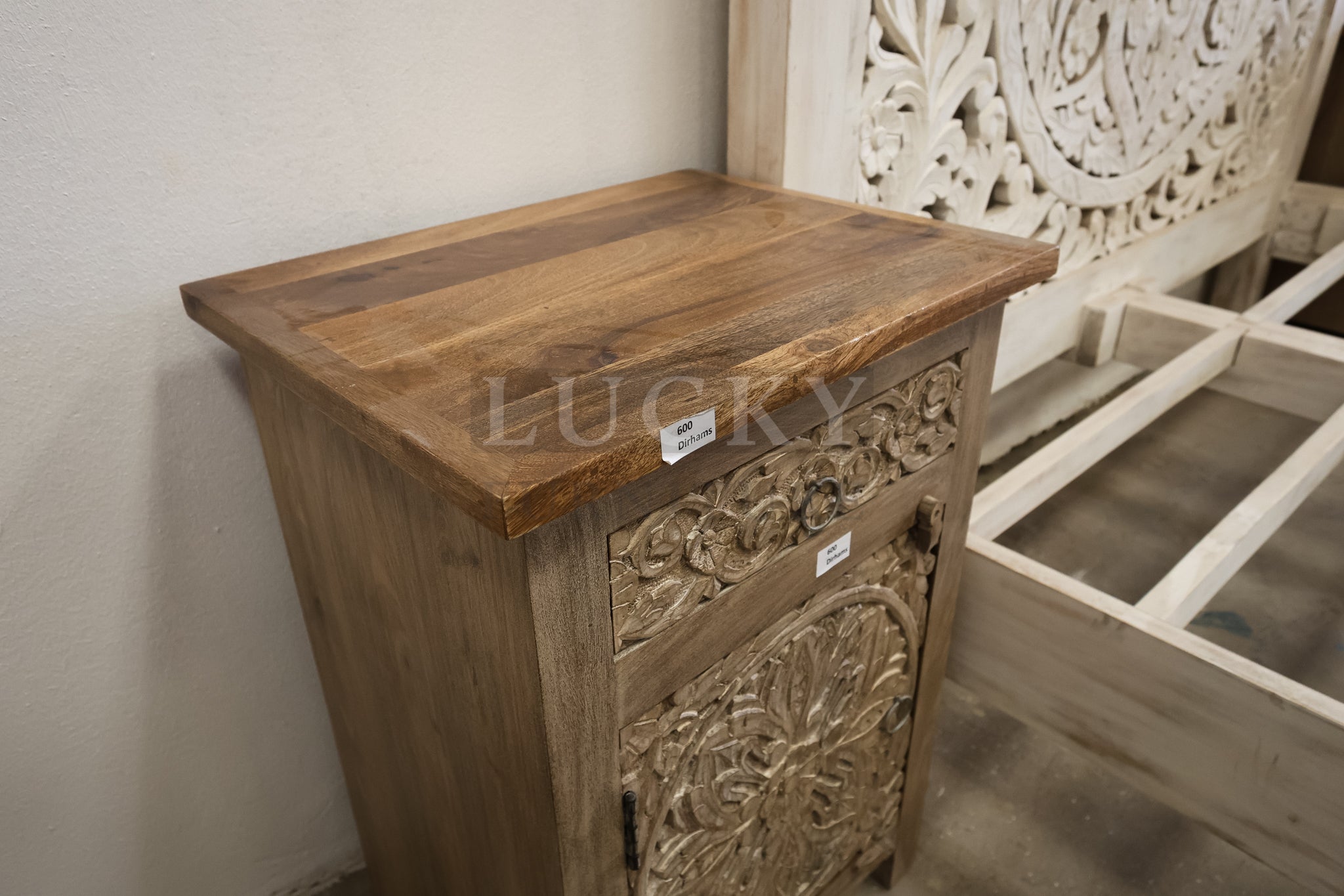 Carved whitewashed wooden bed.