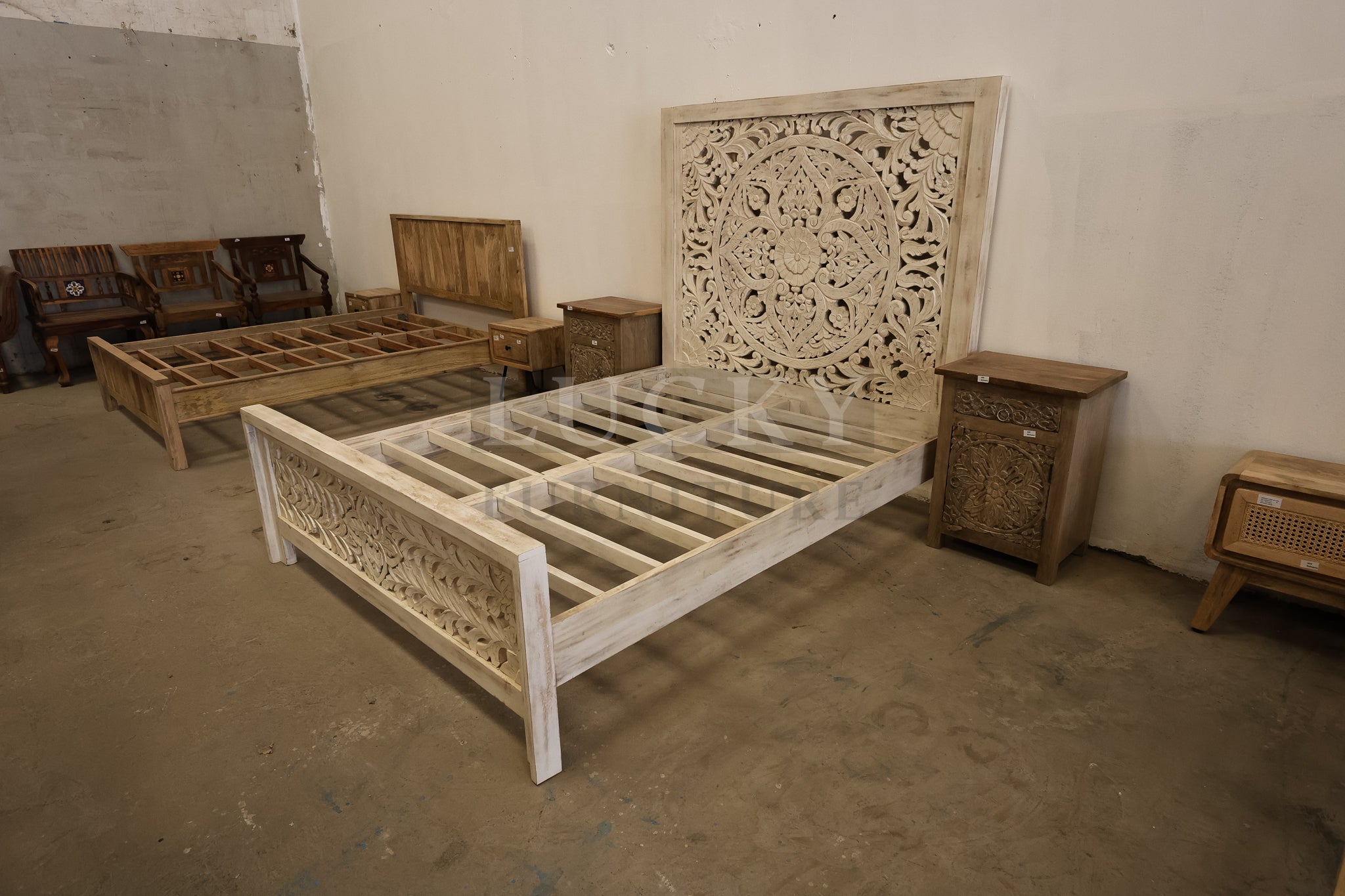 Carved whitewashed wooden bed.